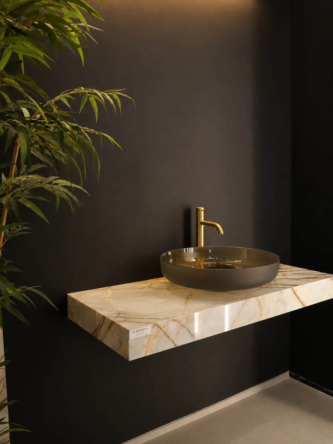 Lavabo da appoggio con rubinetto dorato su mensola effetto marmo